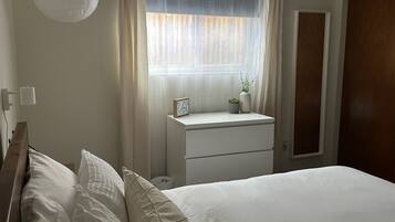 2 habitaciones, escritorio y tabla de planchar con plancha