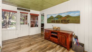 A room with a wooden floor, a wooden cabinet, and a painting on the wall.