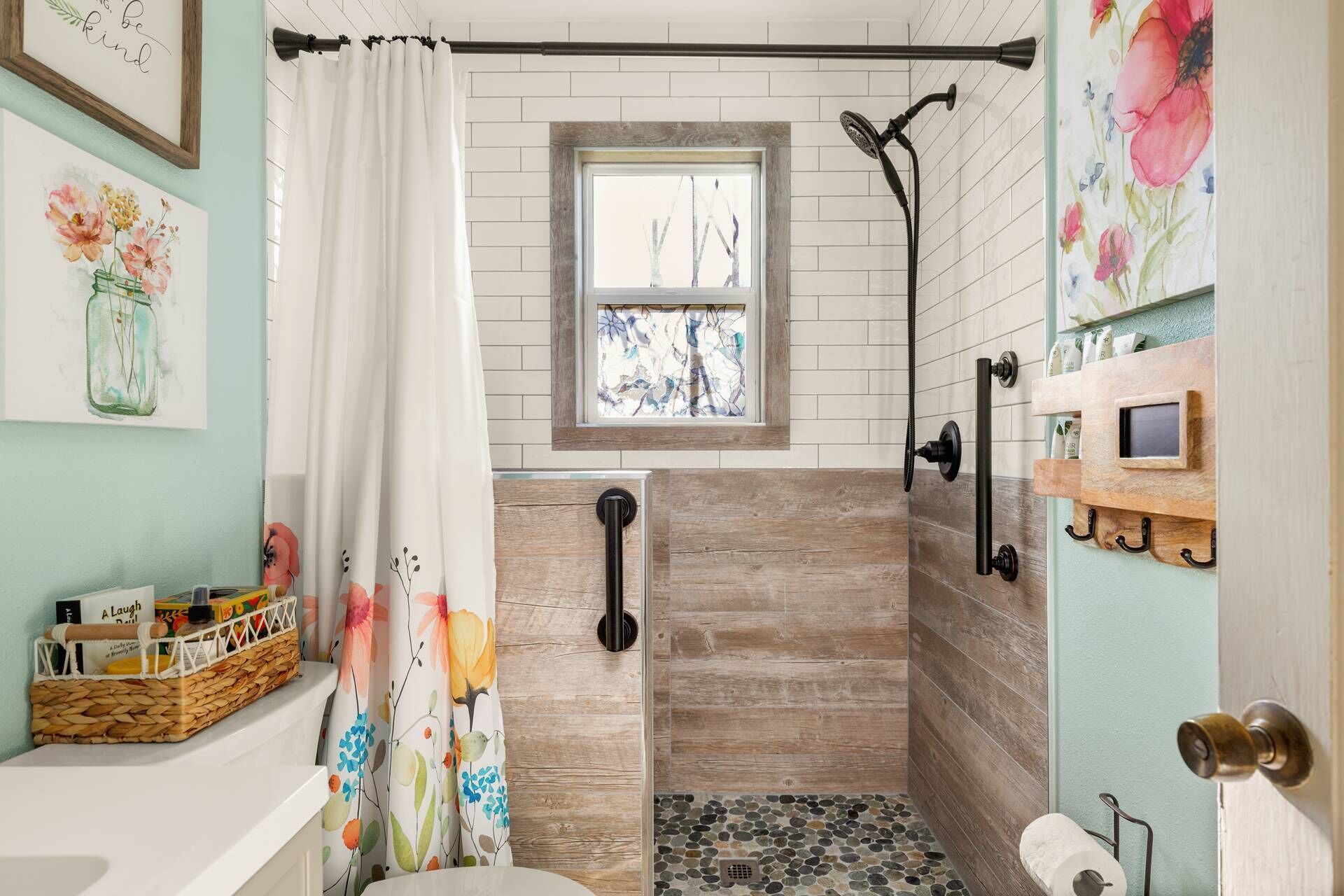 Een badkamer met een douche, een raam, een houten vloer en een toilet.