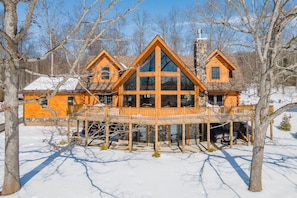 A log cabin with a large glass front and a wooden deck. - Luxury Deep Creek Stay w/ Fire Pit & Views (Swanton)