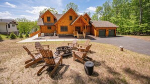 A log cabin with a fire pit and Adirondack chairs in the yard. - Luxury Deep Creek Stay w/ Fire Pit & Views (Swanton)