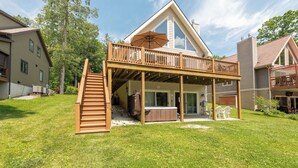 A two-story house with a wooden deck, a hot tub, and a covered patio area. - Cozy Lake Escape Near State Park & Slopes (Swanton)