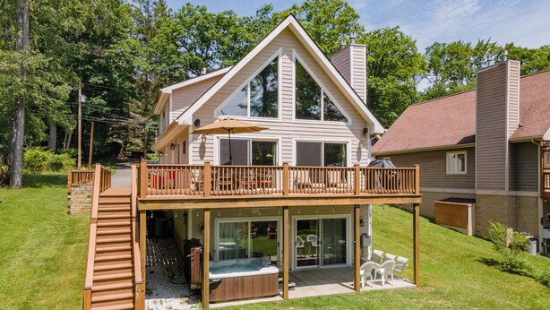 A two-story house with a deck, a hot tub, and a covered patio area. - Cozy Lake Escape Near State Park & Slopes (Swanton)