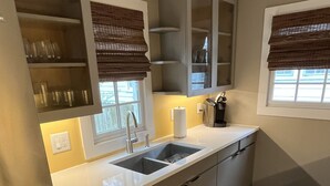Eine moderne Küche mit einem Edelstahlkühlschrank, einer Spüle mit zwei Becken und eingebauten Schränken.