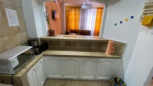 A compact kitchen with white cabinets, a microwave, and a coffee maker. - Departamento En La Garzota a  5 mnts del Aeropuerto (Guayaquil)
