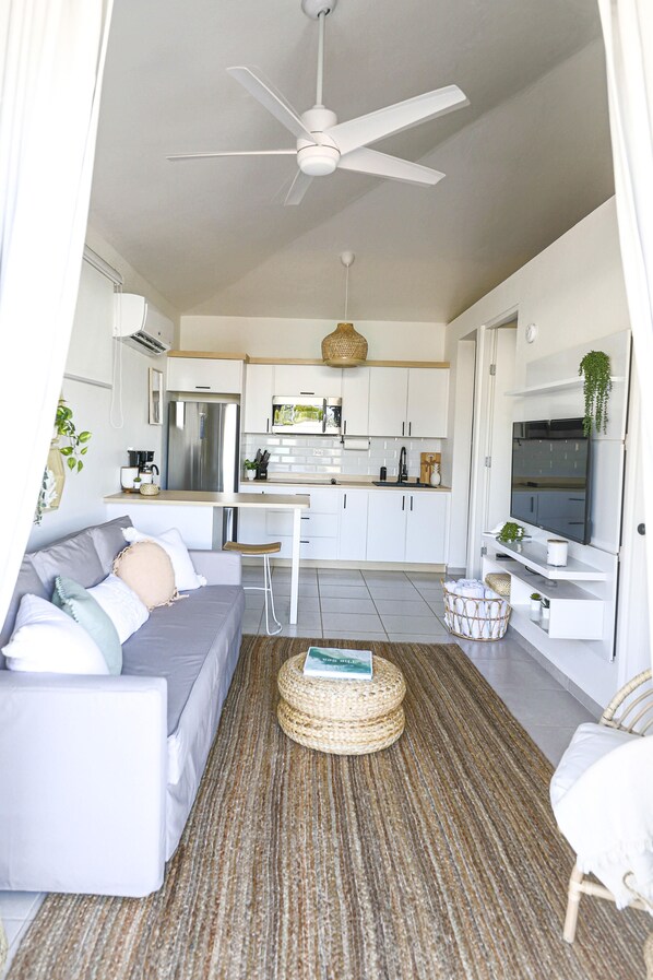 A modern living room with a grey sofa, a coffee table, and a TV.