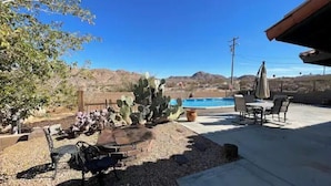 A patio with a pool, cactus plants, and outdoor furniture. - The Peaceful Retreat (5 min from the park entrance w/ Pool! (Joshua Tree)