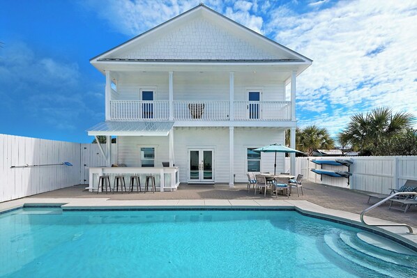 A two-story white house with a swimming pool, outdoor seating, and a fenced backyard. - Epic! Ocean views! Sleeps 20! Pool! Golf cart! (Destin)