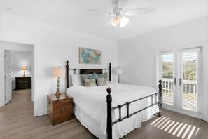 A bedroom with a bed, a nightstand, a ceiling fan, and a view through a door. - Epic! Ocean views! Sleeps 20! Pool! Golf cart! (Destin)
