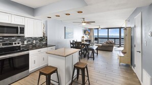 A modern kitchen with a large island, a dining area with a view, and a cozy seating area. - Gulf Shores Condo 403 Gorgeous 4th Floor Beachfront View (Port Aransas)