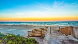 A wooden boardwalk leading to a beach with a clear view of the ocean and a sunset in the background. - Gulf Shores Condo 403 Gorgeous 4th Floor Beachfront View (Port Aransas)