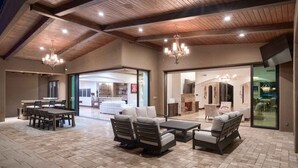 Un vaste patio intérieur doté d’un haut plafond, de meubles modernes et d’une cheminée.