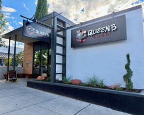 A restaurant named 'Queen B Sushi' with a modern exterior and signage.
