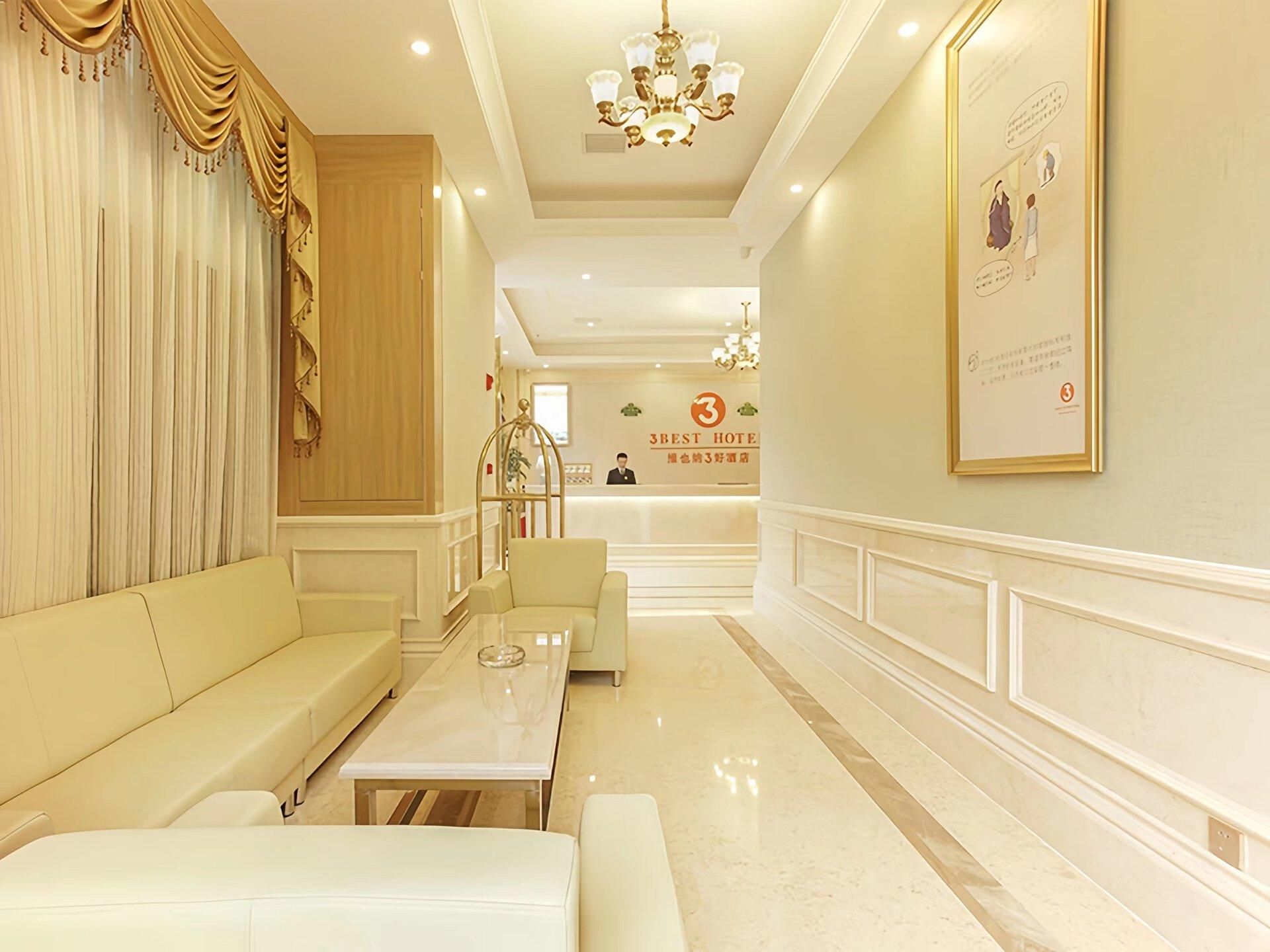Un vestíbulo de hotel con mostrador de recepción, zona de estar y un candelabro.