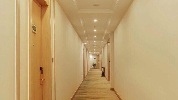 A hotel hallway with wooden doors, a carpeted floor, and recessed lighting. - Vienna 3 Best Hotel (Chongqing Wansheng Hongen Fortune Plaza) (Chongqing)