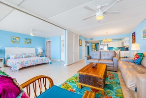 A spacious living room with a sofa, a coffee table, and a bed with floral bedding. - Gulf Shores 504 Gorgeous fifth floor Beachfront View (Port Aransas)