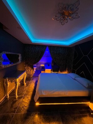 Relax in a serene space with a large bed, bedside table, and decorative lighting.
