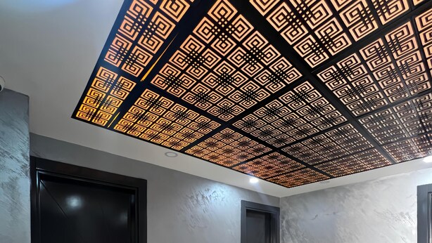 Un pasillo moderno con suelo de mármol, puertas negras y un diseño decorativo en el techo.