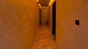 Un pasillo con suelo de mármol e iluminación cálida.