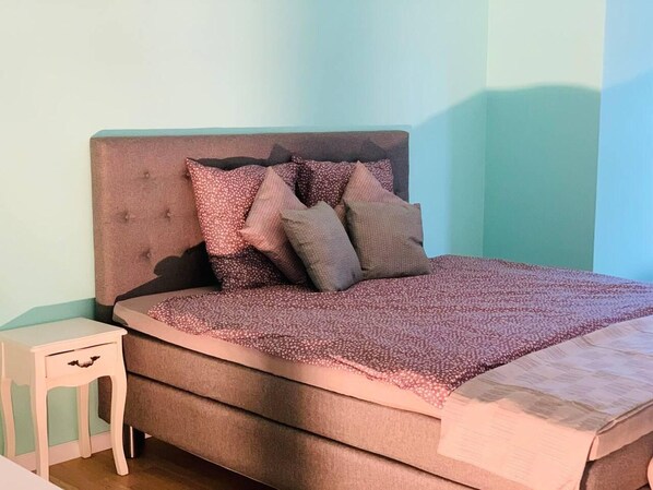 A bedroom with a bed, pillows, and a nightstand. - Captivating 4-bed Villa in Idestrup (Idestrup)