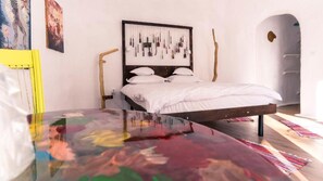 Ein Schlafzimmer mit einem Bett, einem Wandbild und einem Holzboden.