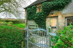 A stone cottage with ivy-covered walls, a metal gate, and a sign reading "CRITCHLOW COTTAGE." - Beautiful Peak District country cottage sleeping three people - dog-friendly (Buxton)