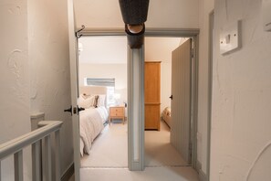 A hallway leading to a bedroom with a bed, nightstand, and wardrobe. - Country cottage for four people set in 12 acres of Peak District National Park (Buxton)