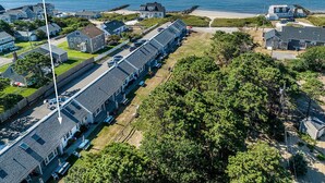 A coastal residential area with a row of houses, a beach, and a clear view of the ocean. - Studio steps to a private beach!! Ocean views from backyard!! 2 Paddle Boards!!  (Dennis)