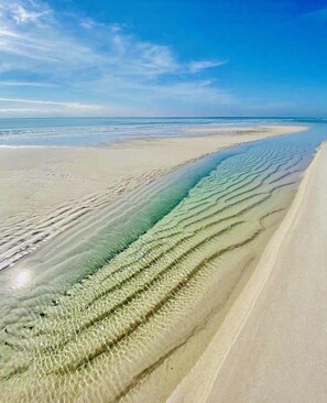 Ein Strand mit klarem Wasser und einem Sandstrand.