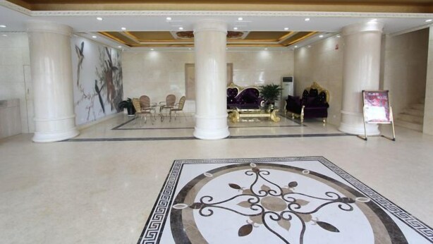 A spacious lobby with marble flooring, large columns, and a central seating area with a sofa and chairs. - Zhaoqing Dengfeng Business Hotel B (Huaiji)
