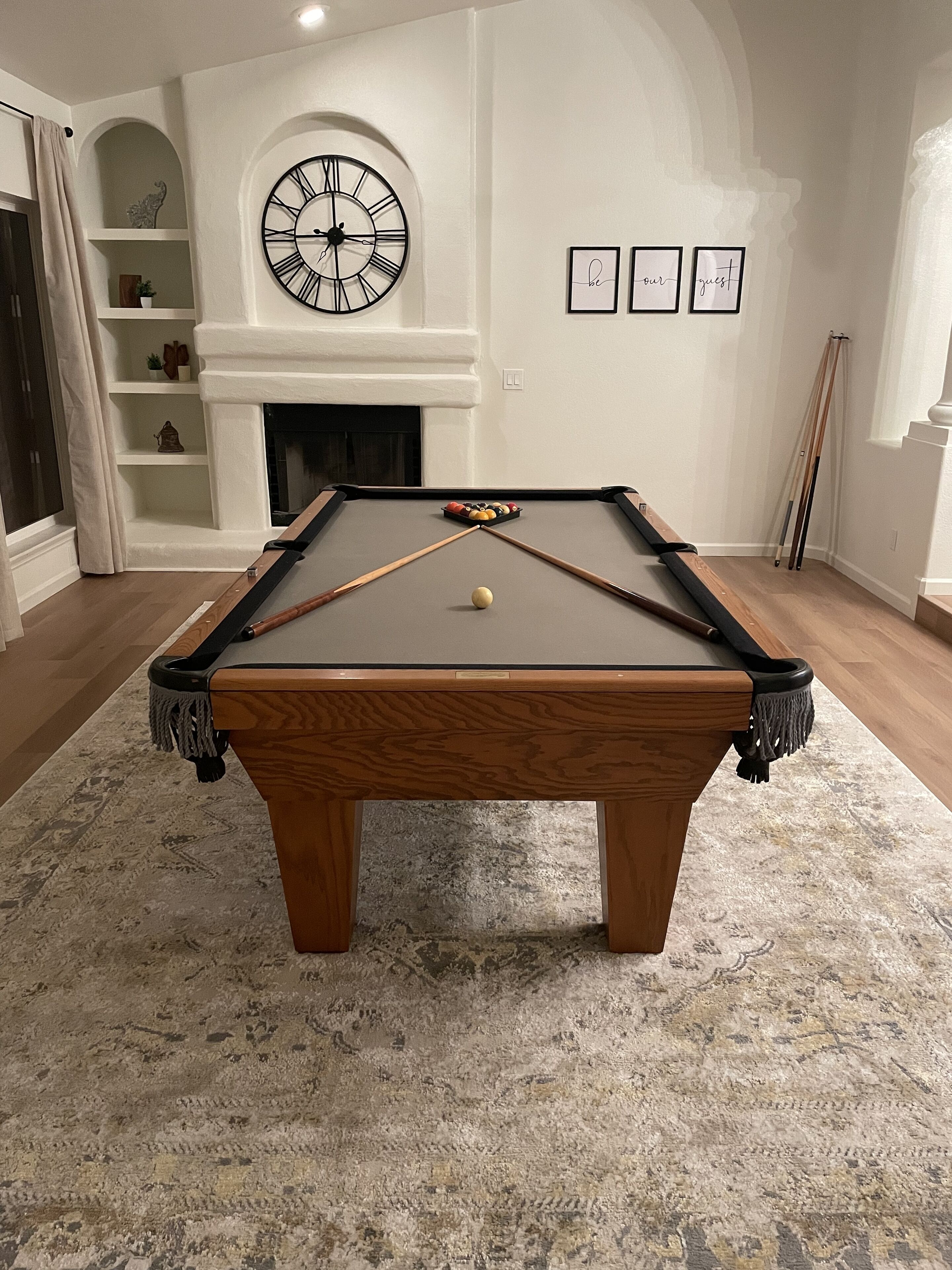Een pooltafel met een witte poolbal in het midden, omringd door een vloerkleed met een patroon.