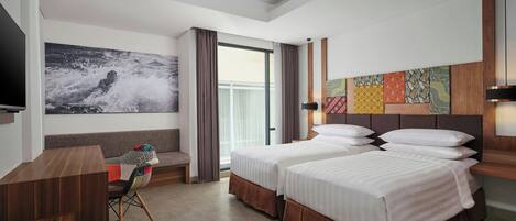 A hotel room with two beds, a desk, a chair, a TV, and a large window.