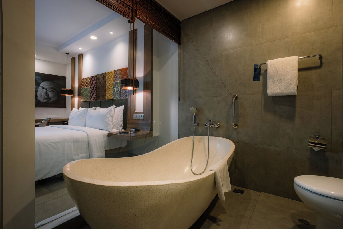 A modern bathroom with a freestanding bathtub, a toilet, and a shower.