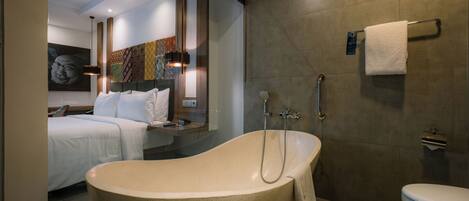 A modern bathroom with a freestanding bathtub, a toilet, and a shower.