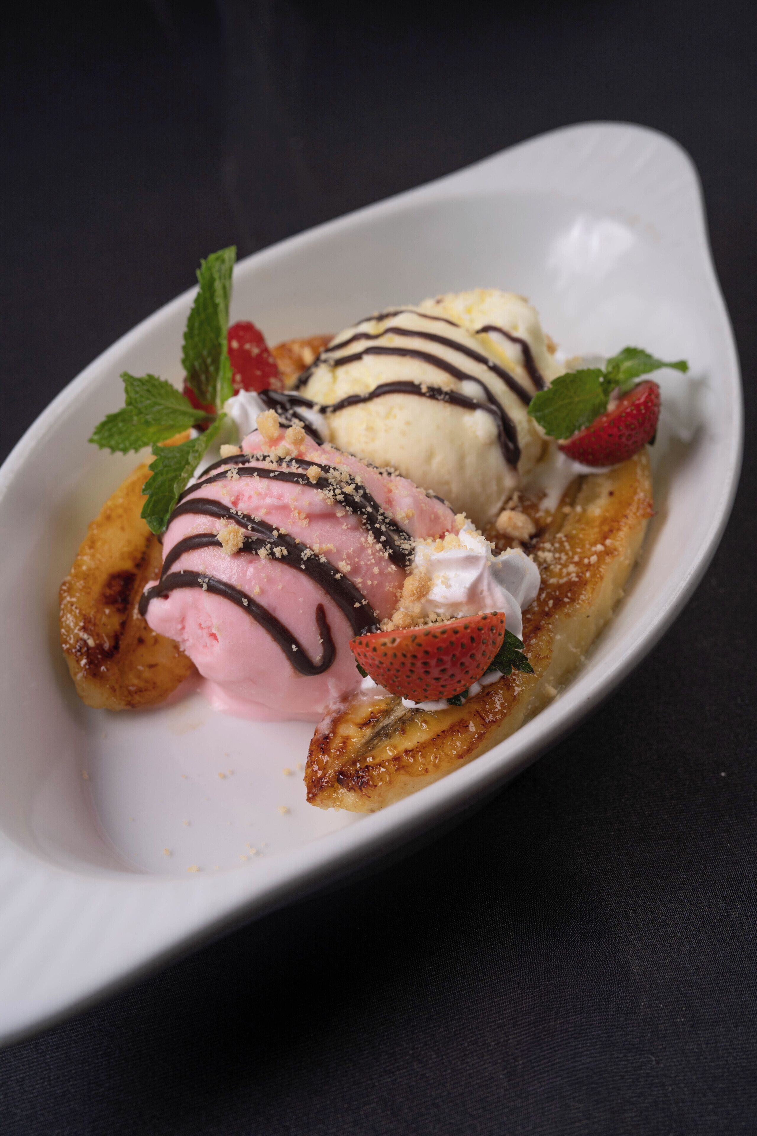 A dessert plate with ice cream and strawberries.