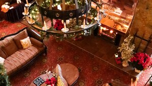 Eine gemütliche Lobby mit Kamin, Sitzgruppe und einer dekorativen Chandelier.