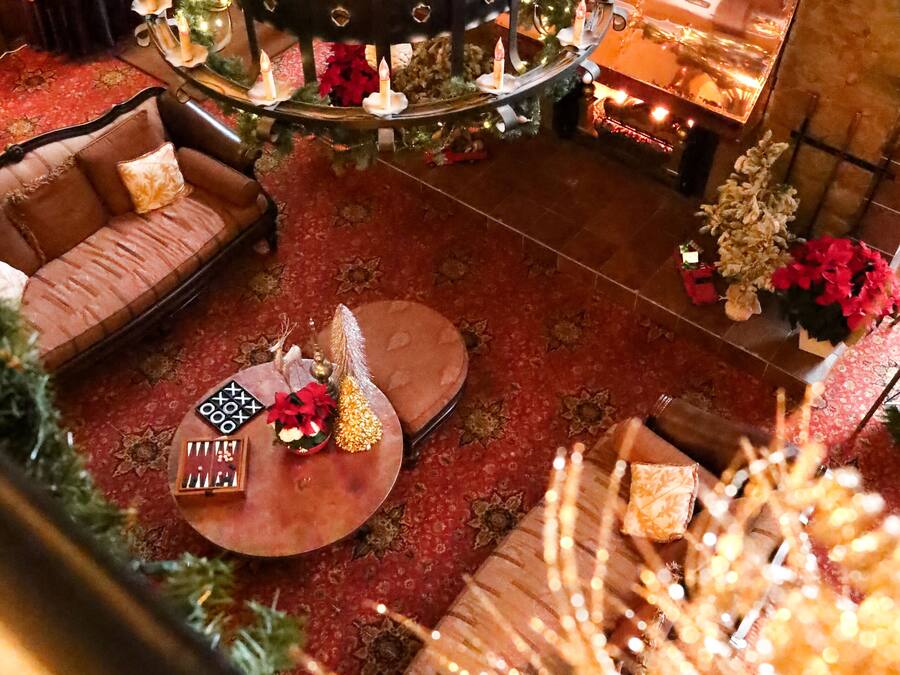 A cozy lobby with a fireplace, seating area, and a decorative chandelier.