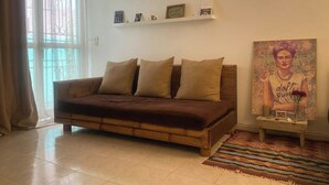 A cozy living room with a brown sofa, a patterned rug, and a painting on the wall. - La Casa Verde x Townhouse in Mermoz, Dakar (Dakar)