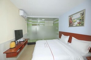 A hotel room with a bed, a TV, a bedside table with a kettle, and a painting on the wall. - Baorui Hotel (Shenzhen Bao'an International Airport T3 Terminal Hourui Subway Station) (Shenzhen)