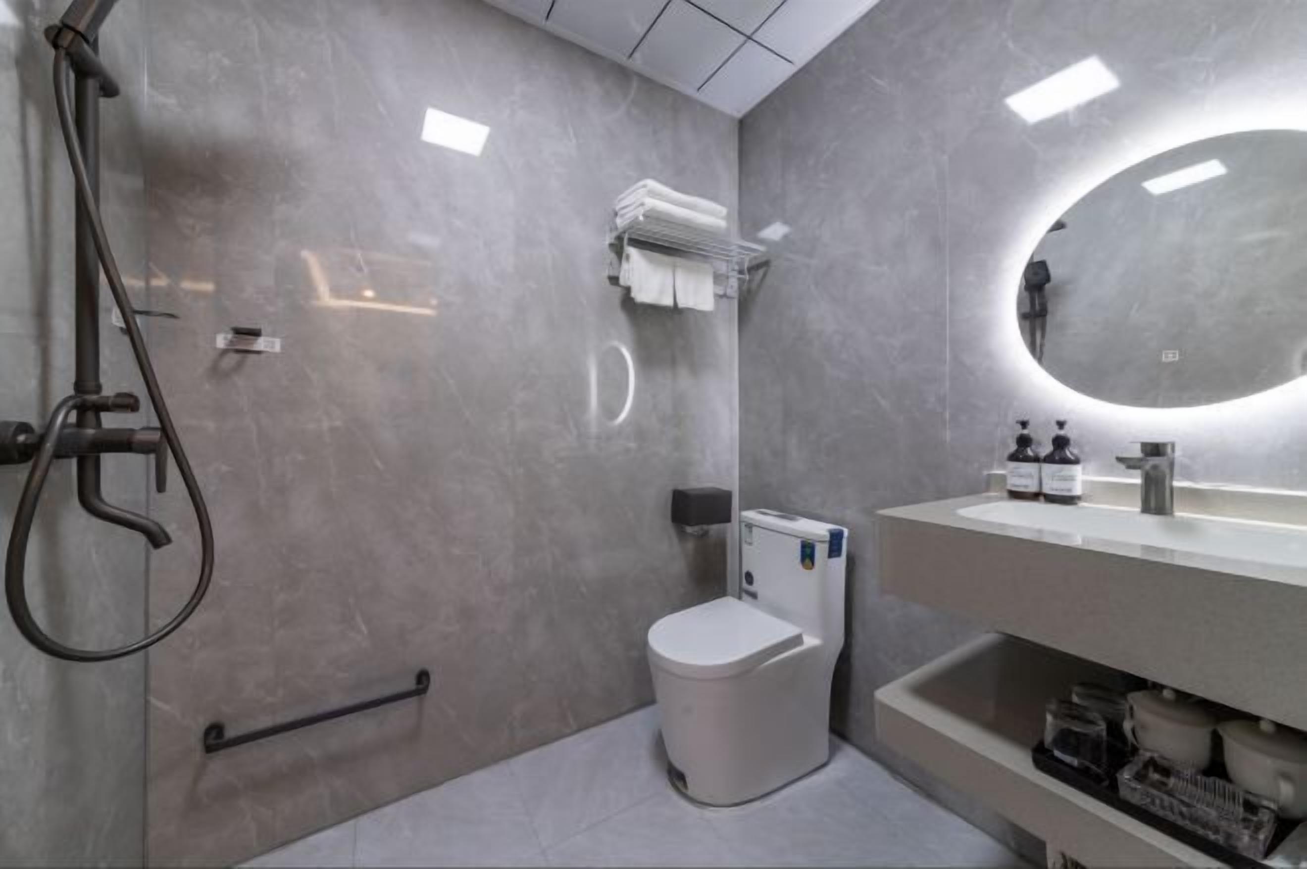 Un baño moderno con inodoro, lavamanos y ducha.
