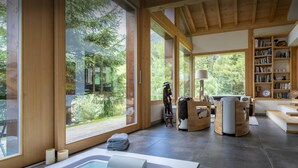 Ein modernes Interieur mit einem großen Fenster, einer Whirlwanne und einer Bücherwand voller Bücher.
