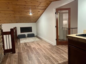Cozy retreat with a sloped ceiling, bench, and large window.