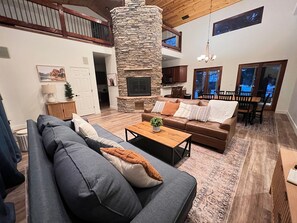 Cozy living area with a stone pillar, leather sofa, and fireplace.
