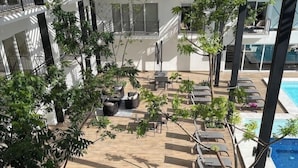 En tagterrasse med liggestole, et lille bord og krukkeplanter.