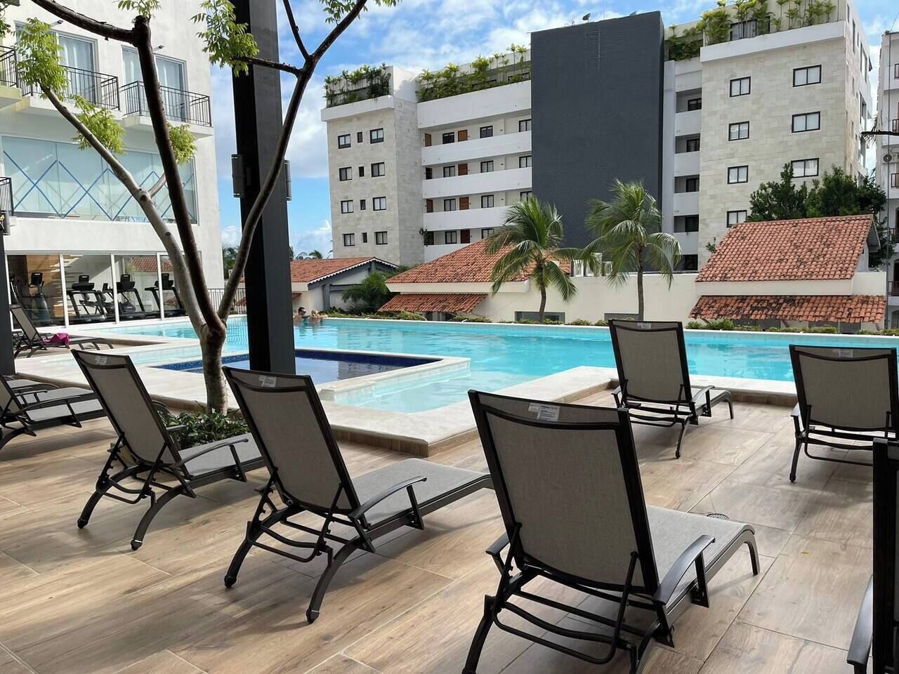 Un espace aménagé au bord de la piscine, avec des chaises longues et une piscine.
