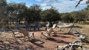 An outdoor seating area with Adirondack chairs and a hammock. - Hill Country Lodge * Great for Groups & Multi Family Gatherings (Doss)