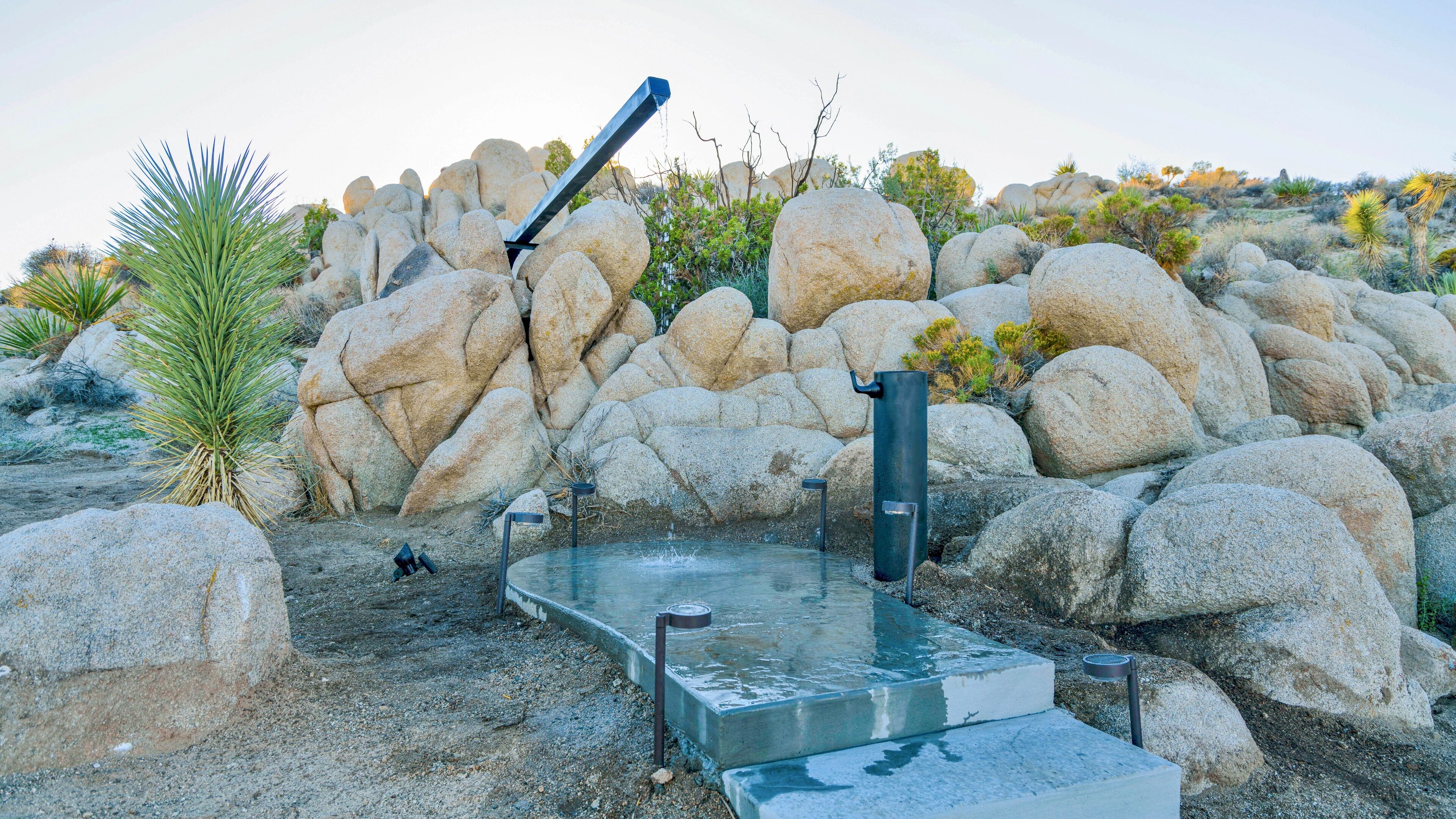 A rock garden with a water feature, including a fountain and a small pool.
