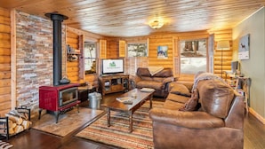 A cozy log cabin interior with a fireplace, leather furniture, and wooden walls. - Amazing Secluded Cabin On 10 Acres, Close To Breck (Fairplay)