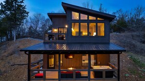 A modern two-story wooden cabin with a balcony and large windows. - Perfect Modern Cabin for Couples Hot Tub Indoor Fireplace Pet friendly (Sevierville)
