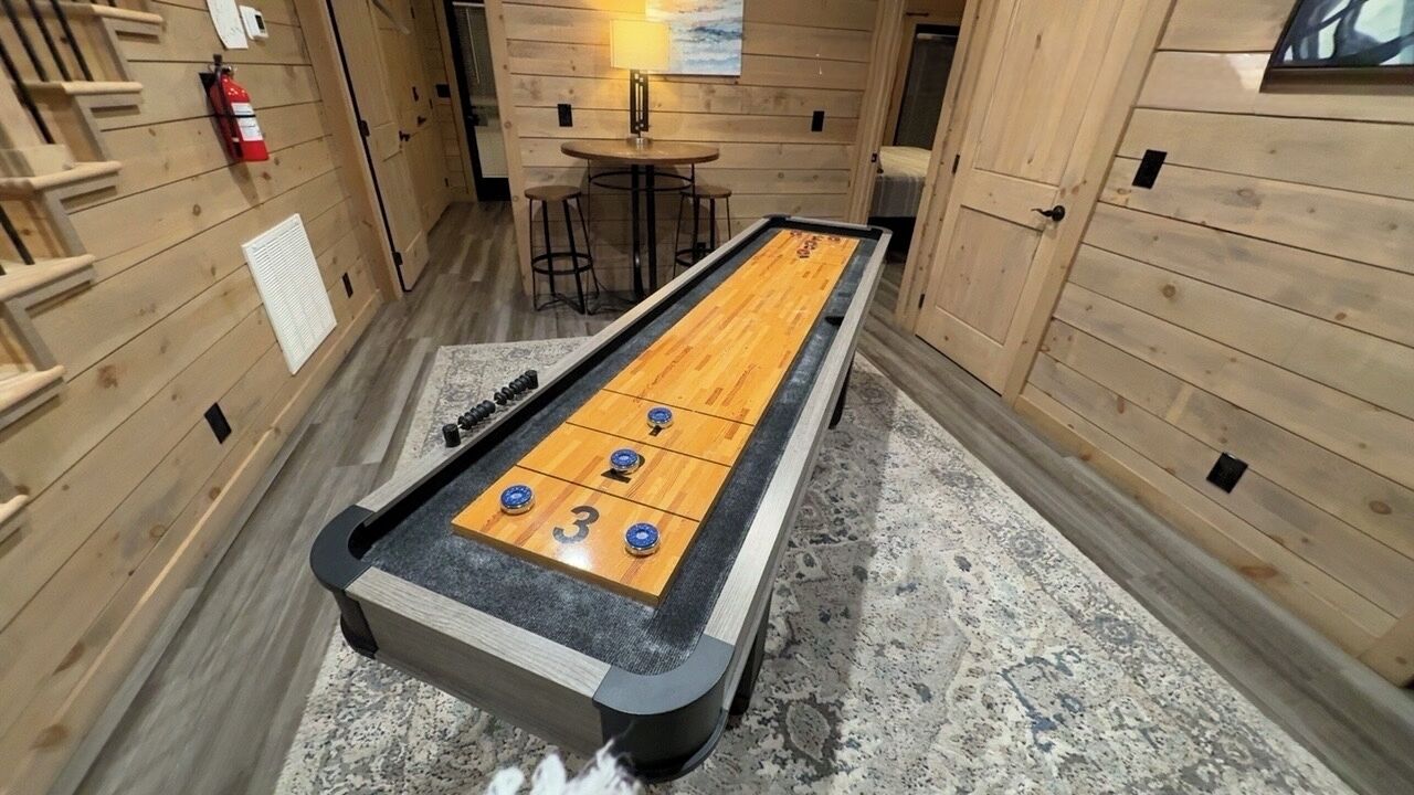 Une table de jeu de palet est installée dans une pièce en bois, et un extincteur est fixé au mur.